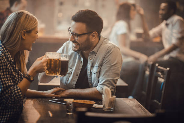 istock Cheerful couple communicating while toasting with beer in a pub. 931586800