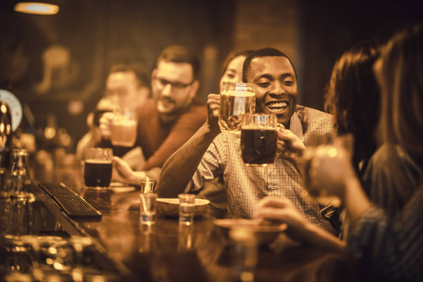istock Large group of people drinking beer during night out in a bar. 931587856