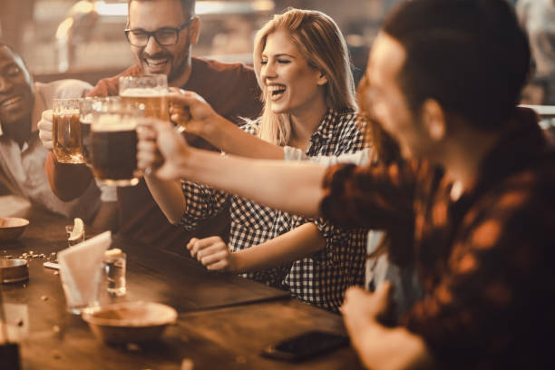 istock Group of young joyful friends having fun while toasting with beer in a pub. 931591024