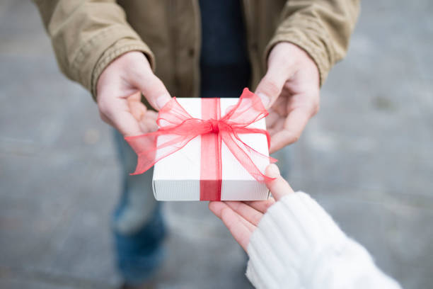 Men and women hand over a gift box