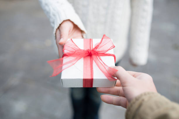 istock Men and women hand over a gift box 931591812