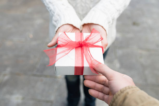 istock Men and women hand over a gift box 931591880