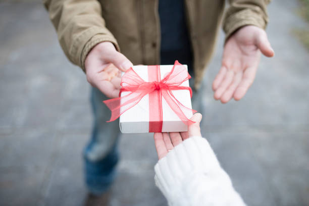 istock Men and women hand over a gift box 931591968