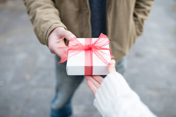 istock Men and women hand over a gift box 931592082