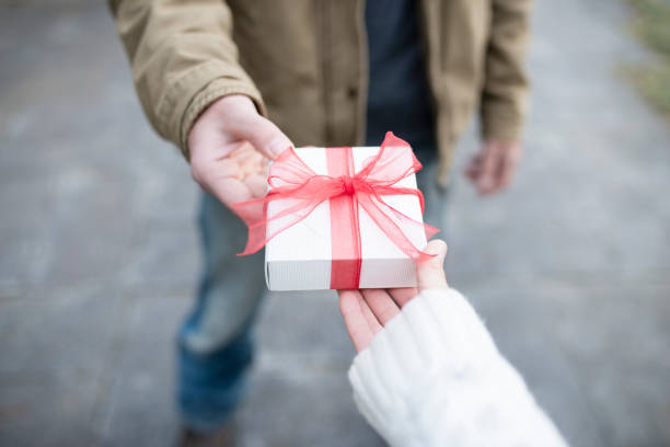 istock Men and women hand over a gift box 931592086