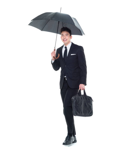 istock Businessman holding an umbrella walking 931592350