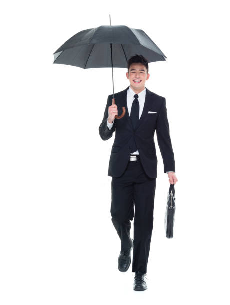 istock Businessman holding an umbrella walking 931592352