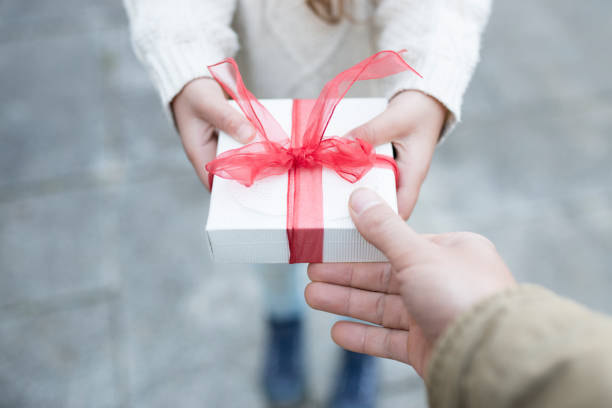 istock Parent and child hand handing present box 931592370