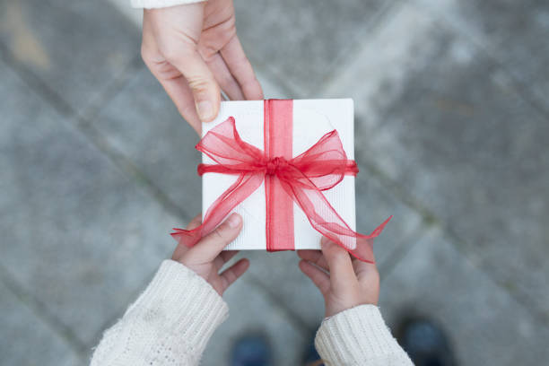 istock Parent and child hand handing present box 931592534