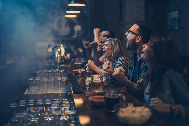 istock Young excited fans having fun in a bar while cheering for their favorite team. 931594974