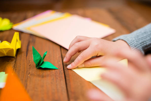 istock Children's hand playing with origami 931595484