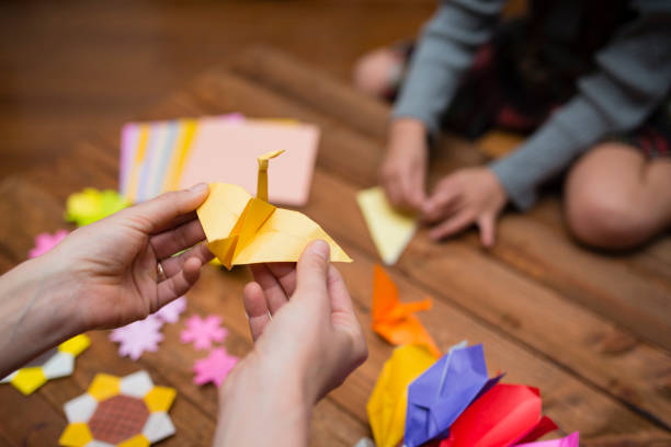 istock Parent and child hand playing with origami 931595570