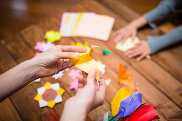 istock Parent and child hand playing with origami 931595592