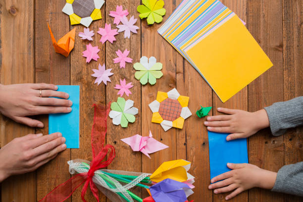 istock Parent and child hand playing with origami 931595918