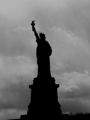 A black and white silhouette of the Statue of Liberty
