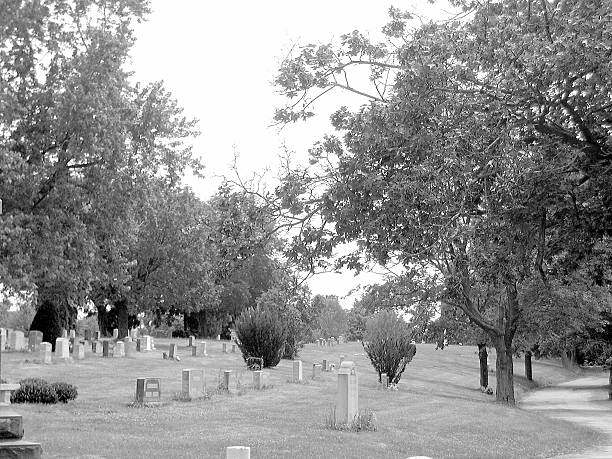 An old grave surrounded by an iron fence in a pioneer cemetery.