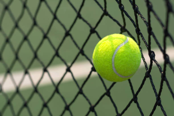 istock Close up tennis ball hitting to net on blur background 931615950
