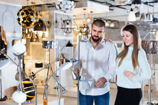 istock Smiling couple customers choosing floor lamp with a long standard in store 931617340