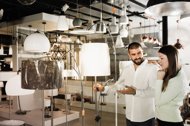 istock Smiling couple customers choosing floor lamp with a long standar 931617348