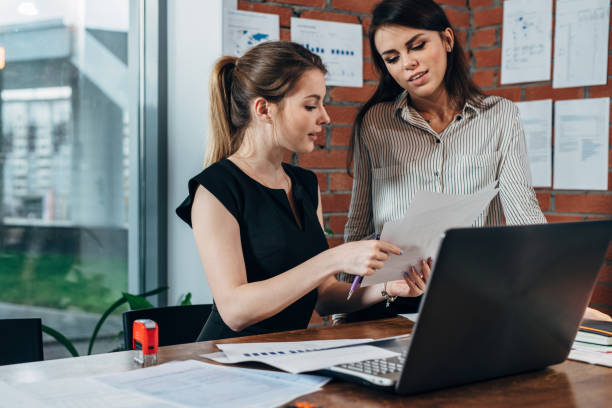 istock Female secretary looking concerned while her boss checking document sitting at desk in modern office 931617468