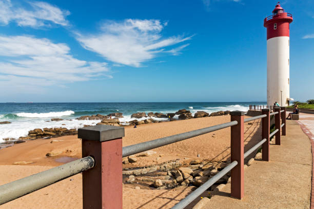 istock Barrier Against Red and White Lighthouse and Blue Seascape 931620928