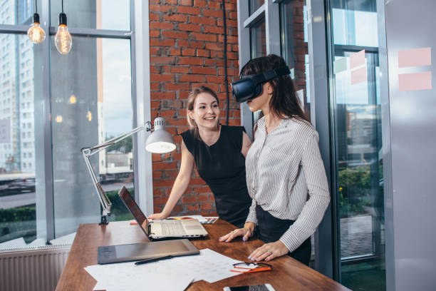 istock Two female students playing a 3d game in VR glasses having a break after a lesson in the classroom 931620942