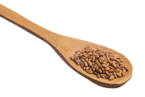 istock Wooden Spoon With Wheat Against White Background 931627640