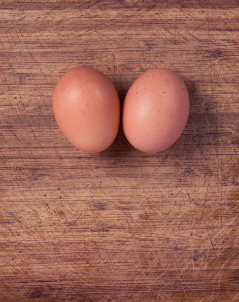 direttamente sopra il colpo di uova marroni sul tavolo - two eggs foto e immagini stock