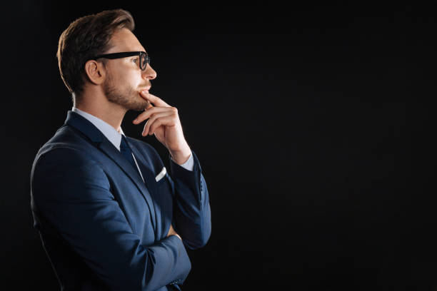 istock Thoughtful bespectacled man looking aside touching to his chin 931628978