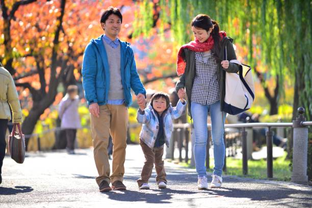 pareja japonesa y su hijo paseando en el parque de ueno, tokio - orange sauce fotografías e imágenes de stock