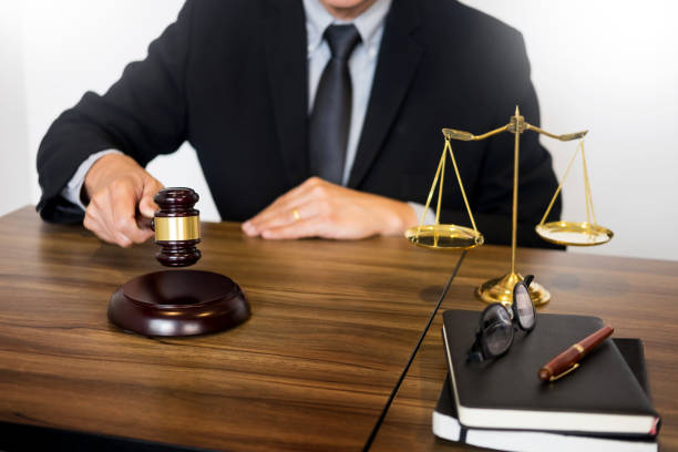 istock Midsection Of Judge Holding Gavel Against White Background 931633196