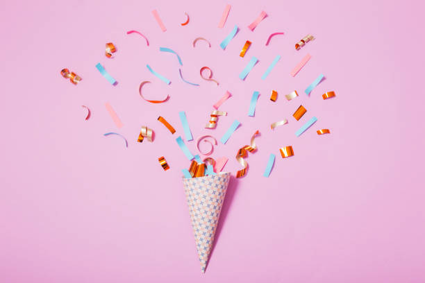 istock birthday hat with confetti on paper background 931640158
