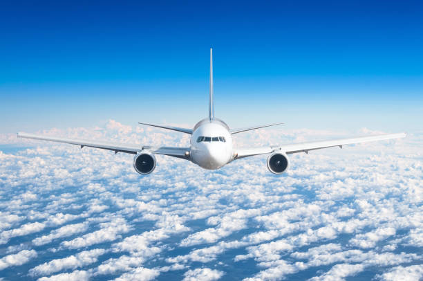 istock Passenger airplane flying at flight level high in the sky above the clouds and blue sky. View directly in front, exactly. 931648162