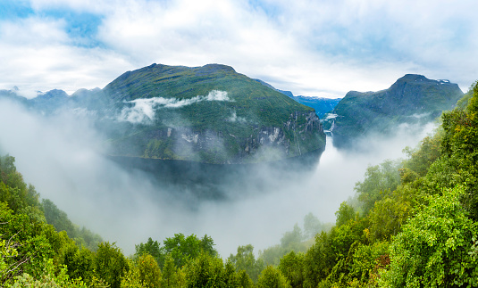 panoramic view of Norwegian fjord and mountains in the clouds; Norway