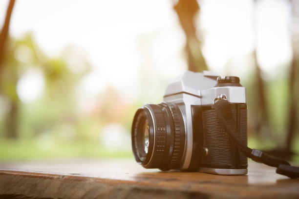 istock Vintage camera on wooden table with blurred nature background. 931648582