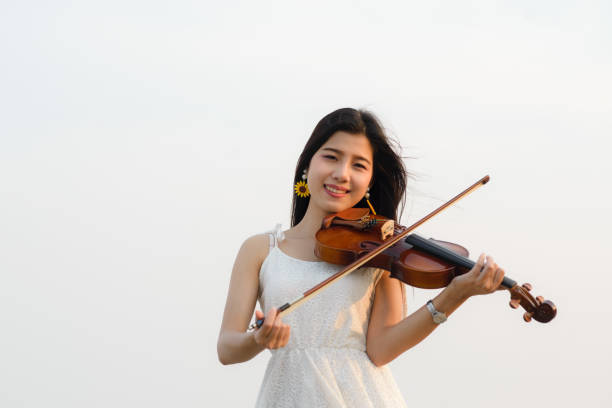 istock Happy woman playing violin on the beach. 931648952
