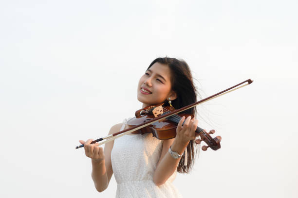 istock Happy woman playing violin on the beach. 931648962