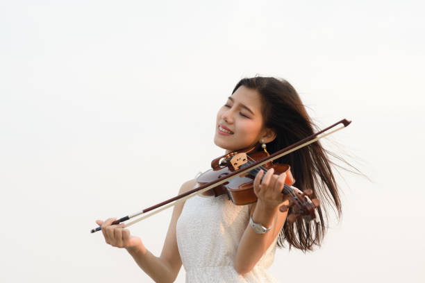 istock Happy woman playing violin on the beach. 931648982