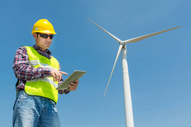 istock Electric Engineer use Digital Wireless Tablet Device with Wind turbine power Generator 931649648