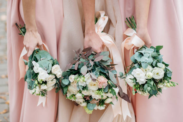 fiori nuziali in mano alla sposa e alle sue damigelle. - bride bouquet foto e immagini stock