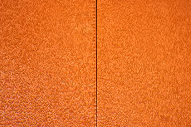 istock Orange leather texture. Leather stitched fabric. background.Close-up 931657362