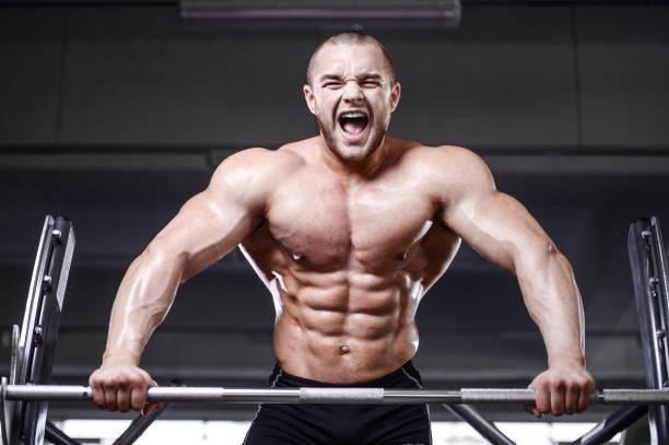 istock Brutal strong bodybuilder athletic men pumping up muscles with dumbbells 931661190