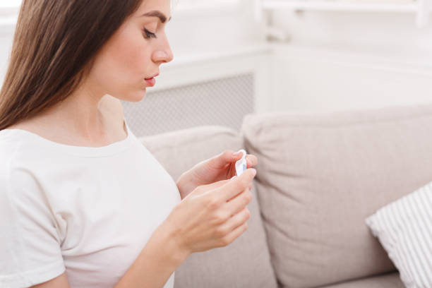 istock Worried girl with pregnancy test sitting on sofa 931661712