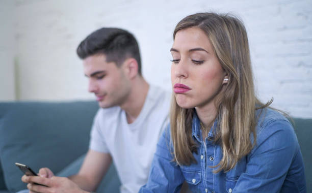 istock young attractive couple in relationship problem with internet mobile phone gambling addict boyfriend ignoring sad neglected and bored girlfriend at home couch feeling depressed and lonely 931662656