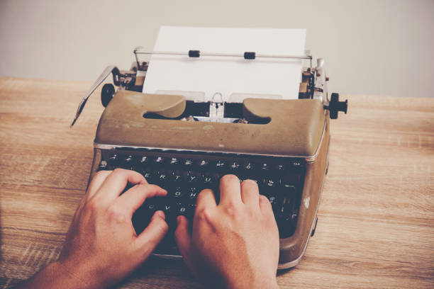 istock Hands typing on vintage typewriter on wooden table. 931663150