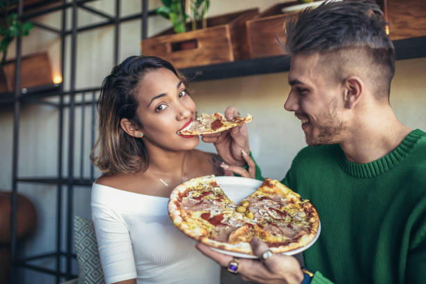 istock Mixed race couple eating pizza in cafe 931667098