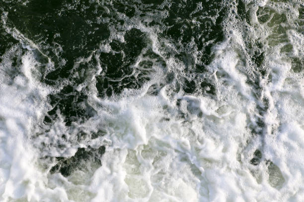istock stormy creek. wave and foam in the flow. splashes, bubbles, waves, stream, ripples and crests of waves in a fast forest stream in winter 931670374