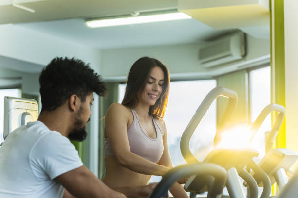 istock Fitness instructor helps young woman on treadmill 931674542