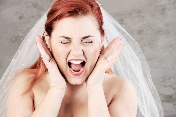 Funny red haired bride is screaming with hands up. stock photo