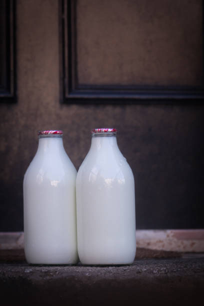botellas de leche entregados a un hogar en el reino unido - milkman fotografías e imágenes de stock